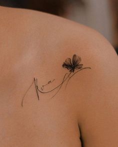 a woman's shoulder with a flower tattoo on it