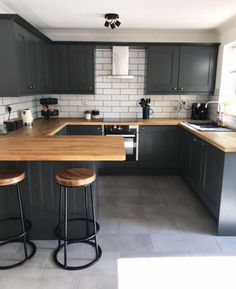 an image of a kitchen setting with bar stools and counter top in the middle