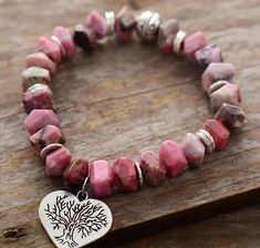 Get inspired  by the  charming nature  with Great Collection of hand made Jewelry , All our Jewelry is  made by hand  and one of a kind , Each stone has been carefully selected with the  best quality  to give you a  truly unique handmade Piece , This Unique Nature's Heart Rhodonite Stretch Bracelet from our new collection is hand made with a magical touch of natural stones and beads ( Rhodonite Stone Beads ) added to a heart charm with Tree symbol to give Handmade Charm Bracelets, Spiritual Bracelets, Treasure Jewelry, Tree Of Life Bracelet, Tree Of Life Jewelry, Stone Wrapping, Natural Stone Bracelets, 7 Chakras, Nature Inspired Jewelry