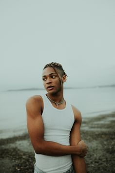 a man with dreadlocks standing by the water