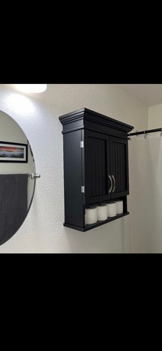 a bathroom with a sink, mirror and toilet paper dispenser on the wall