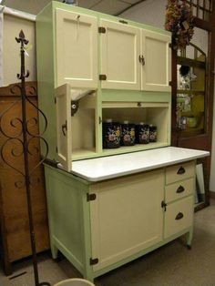 an old fashioned green and white kitchen cabinet