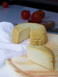 a piece of cheese sitting on top of a wooden cutting board