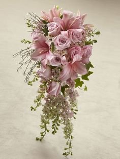 a bouquet of pink flowers sitting on top of a white table next to a wall