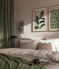 a bed with white linens and green curtains