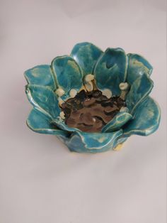 a blue and green flower shaped bowl sitting on top of a table