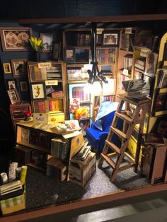 a room filled with lots of books and ladders next to a table full of boxes