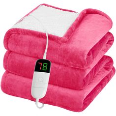 a pink blanket with a thermometer on it and two blankets stacked up next to each other