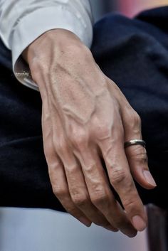 a close up of a person's hand with a ring on it