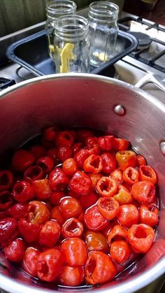 red peppers are being cooked in a pot on the stove top with water and lemons