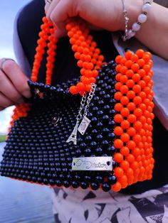 A bright and roomy daily handmade beaded handbag. This women's purse is large and holds everything you need, a mobile phone of any size, a small wallet, a power bank, a mirror, lipstick, keys, a bottle of your favorite perfume, and there is also room for trinkets. The bag is woven with black acrylic beads, while the sides, bottom and handles were woven with bright orange beads for accent.  The bag is lined and closes with a magnetic clasp. Also, the handbag is additionally decorated with small p Everyday Rectangular Shoulder Bag With Colorful Beads, Beaded Tote Shoulder Bag, Everyday Beaded Pouch Bag, Everyday Beaded Tote Shoulder Bag, Trendy Beaded Tote Bag, Beaded Pouch Bag For Daily Use, Square Beaded Bag For Everyday Use, Rectangular Beaded Bag For Daily Use, Daily Use Beaded Pouch Bag