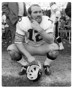 a man kneeling down next to a soccer ball in front of an audience at a football game