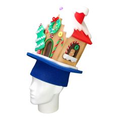 a white mannequin head wearing a blue hat with a gingerbread house on it