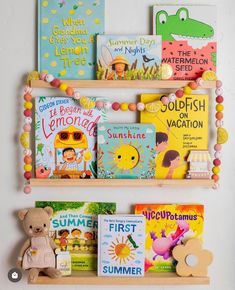 children's books are displayed on wooden shelves with beaded garlands around them