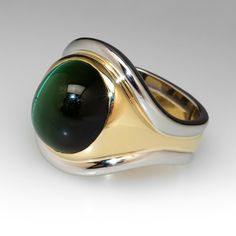 This handsome ring features a central band of eighteen karat yellow gold, bezel set with an oval cabochon cut, natural cat's-eye tourmaline. Two (2) platinum accent bands are attached to the outer edges of the gold band. The ring measures 20.1mm at the top, rises 10.2mm above the finger, tapering to 9.6mm wide and 1.6mm thick at the base of the European style shank. This ring is currently a size 9. Natural Cat, Silver Design, Tourmaline Ring, Oval Cabochon, Gold Platinum, Gold Band, European Style, High Quality Jewelry, Estate Jewelry