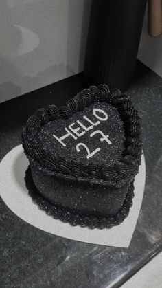 a heart shaped cake with the word hello fifteen on it sitting on top of a white plate