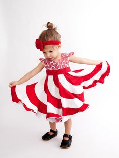 This boutique dress was designed with candy cane kisses and daydreams of candy land in mind. Inspired by the magic of childhood, and the promise of eternal sweetness, this designer dress captures waves of white and red tones and contrasts them against a peppermint candy bodice. The result is a dress that is meant to be twirled and swirled until your little princess can't help fall into the giggles. Each of these dresses are made to order with all seams serged for a professional finish. The purch Fun Red Ruffled Dress, Cute Red Holiday Dress, Playful Red Party Dress, Playful Ruffled Holiday Dresses, Playful Ruffled Dresses For Holidays, Playful Holiday Dresses With Ruffles, Fun Red Dress-up Dresses, Sweet Red Dress With Ruffles, Candy Cane Dress