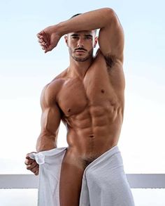 a shirtless man with no shirt on posing for the camera while holding his towel over his head