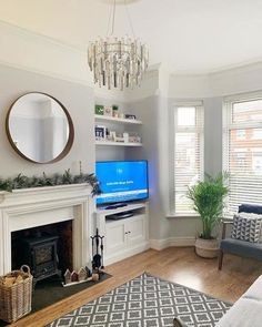 a living room filled with furniture and a flat screen tv mounted on a wall above a fire place