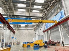 the inside of a large warehouse with lots of steel beams and overhead lights on it