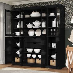 a black bookcase filled with white plates and bowls