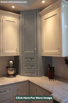 an image of a kitchen setting with white cabinets and marble counter tops in the middle