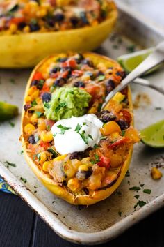 mexican stuffed sweet potatoes with black beans, corn and guacamole on top