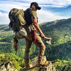 a man hiking up the side of a mountain with a large backpack on his back