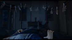 a person laying in bed with paper birds hanging from the line above their head and feet