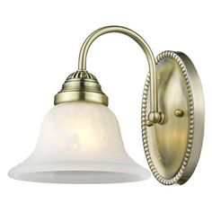 an antique brass wall light with white glass shade