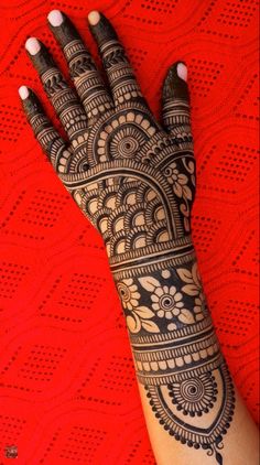 a woman's hand with henna tattoos on it