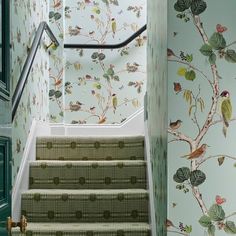 the stairs are decorated with wallpaper and birds on them, as well as green doors