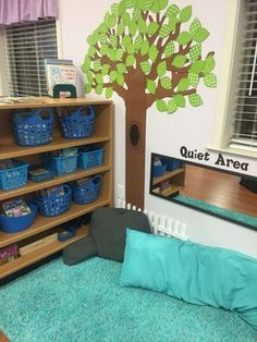 a child's room with a tree painted on the wall and shelves filled with toys