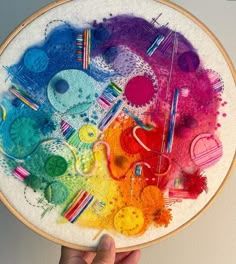 someone is holding up a cross stitch art project that looks like they have been made with colored crayons