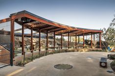 an outdoor covered area in the middle of a park with trees and bushes around it