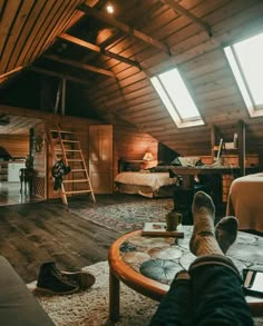 a person's feet resting on a coffee table in a loft