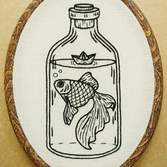 an embroidered picture of a fish in a bottle