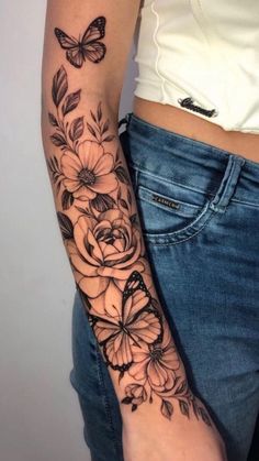 a woman's arm with flowers and butterflies on it