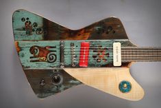 an electric guitar made out of wood with pictures on the top and bottom of it