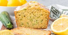 a loaf of zucchini bread sitting on top of a cutting board next to lemons