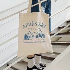 a person standing on some steps with a bag in their hand that says apres ski