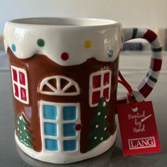 a coffee mug with a christmas themed design on it and a tag hanging from the handle