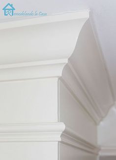 the corner of a room with white paint and molding on the wall above it