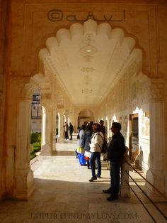 several people are standing in an archway at the entrance to a building with arches and columns