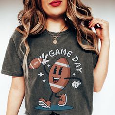 🏈 Ready to tackle game day with style? Our Comfort Colors Game Day Shirt has got your back - and your front! 🙌🍔 This shirt screams, 'I'm here for the touchdowns and tailgates!' 📣🏟️ With a hilarious football character graphic, it's the perfect way to announce your game day priorities: snacks, cheers, and more snacks! 🍕📢 Football Season is upon us, and you'll be the star player in this Football Mama Shirt. Whether you're a sports mom or just love the thrill of the game, this tee is your MVP Team Spirit Tops For Game Day Sports Season, Sports Fan Tops With Team Logo For Game Day, Game Day Sports Fan Tops For Football Season, Football Season Sports Fan Tops, Sports Fan Tops For Football Season Game Day, Sports Fan Tops For Game Day During Football Season, Sporty Crew Neck Top For Tailgating, Crew Neck Tops For Football Season Game Day, Collegiate Tops For Football Season Tailgating