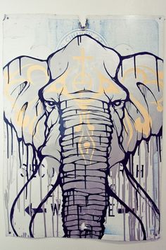 an elephant with yellow paint on it's trunk is shown in front of a white wall