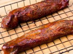 two pieces of meat sitting on top of a cooling rack