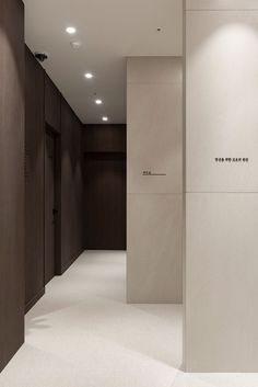 an empty hallway with white carpet and wooden walls