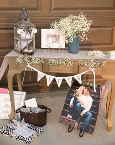 a table topped with pictures and flowers next to a vase filled with baby's breath