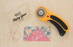 a pair of scissors sitting next to a piece of fabric and some sewing supplies on a table